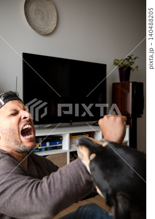 Man is being bitten by a dog. 140488205