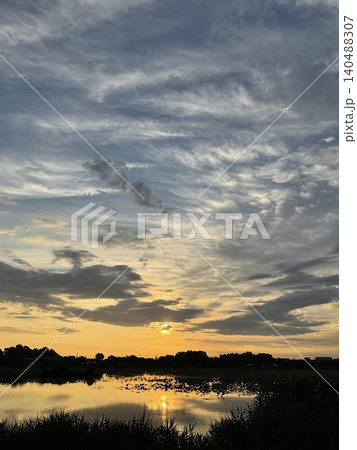 朝焼けの光が水面に反射する美しい城沼の夜明け 朝焼けの光が水面に反射する美しい城沼の夜明け 140488307