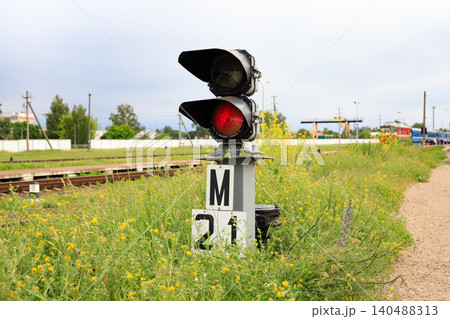 Dwarf railway traffic light with red-light signal standing near the railway tracks. Dwarf railway traffic light with red-light signal standing near the railway tracks. 140488313