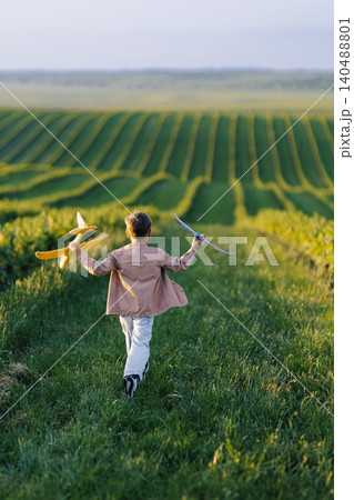 Child running with toy airplanes dreaming of freedom Child running with toy airplanes dreaming of freedom 140488801