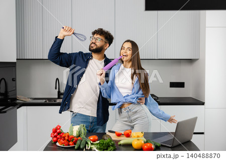 Happy couple singing in kitchen cooking together 140488870