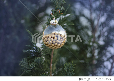 Outdoor natural light illuminates glass ball from multiple angles revealing texture and color of golden bead filling within sphere. 140489595