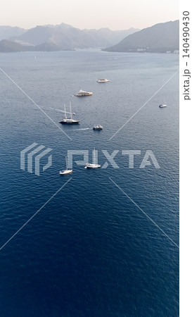 Sunset coastal city. Boats coastal town. Coastal mountain landscape, sea resort yachts, golden hour 140490430