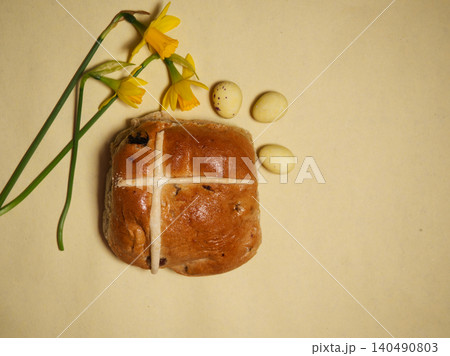 Easter hot cross bun with daffodil flowers yellow background Easter hot cross bun with daffodil flowers yellow background 140490803