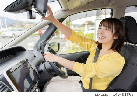 ドライブレコーダーを操作する笑顔の女性ドライバー ドライブレコーダーを操作する笑顔の女性ドライバー 140491863