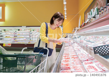 スーパーの精肉売り場で肉を選ぶ女性 スーパーの精肉売り場で肉を選ぶ女性 140491876