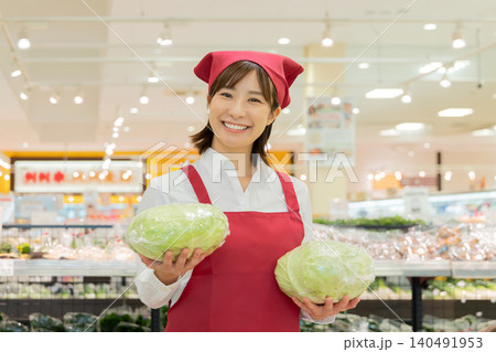 キャベツ持って微笑むスーパーの女性店員 140491953