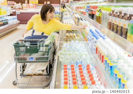 スーパーの飲料売り場で買い物をする車椅子の女性 スーパーの飲料売り場で買い物をする車椅子の女性 140492015