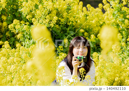 菜の花畑に座る女子高生 菜の花畑に座る女子高生 140492110