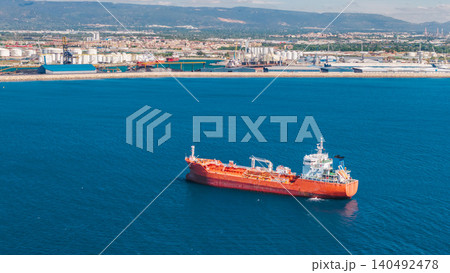 Aerial close up of red industrial tanker ship near Tarragona commercial port and refinery facilities in Spain Aerial close up of red industrial tanker ship near Tarragona commercial port and refinery facilities in Spain 140492478