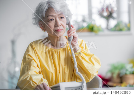 固定電話で電話をするシニア女性 140492890