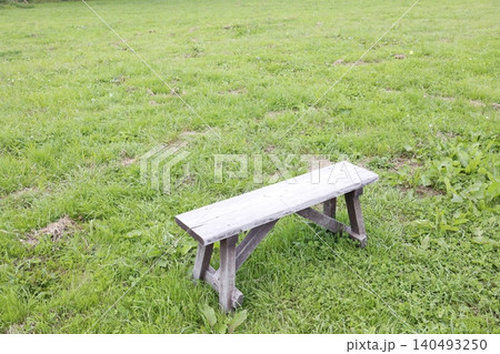 草原の広場にポツンと置かれたベンチ。緑の芝生。静寂の風景 草原の広場にポツンと置かれたベンチ。緑の芝生。静寂の風景 140493250