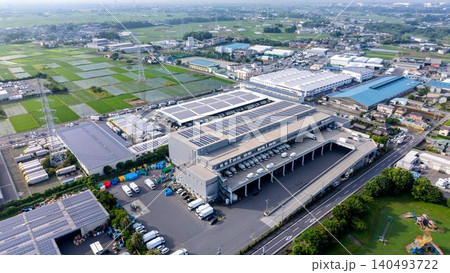【空撮】太陽光パネルを設置した大規模物流センターと郊外の風景 140493722