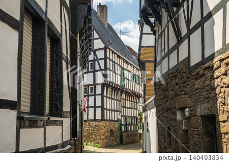 Germany half timbered houses in narrow alley, historic old town european architecture street view, traditional medieval village wooden frame buildings on a sunny summer day Germany half timbered houses in narrow alley, historic old town european architecture street view, traditional medieval village wooden frame buildings on a sunny summer day 140493834