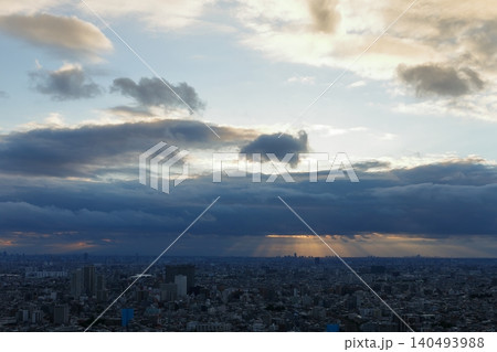 雨雲の隙間から差し込む夕陽と天使の梯子 雨上がりの都市風景 雨雲の隙間から差し込む夕陽と天使の梯子 雨上がりの都市風景 140493988