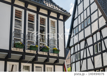 Germany half timbered house windows with flower boxes, historic old town european architecture closeup, traditional medieval village wooden frame facade in summer Germany half timbered house windows with flower boxes, historic old town european architecture closeup, traditional medieval village wooden frame facade in summer 140494076