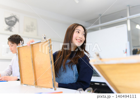 美術予備校で笑顔で制作する女子学生 140494111