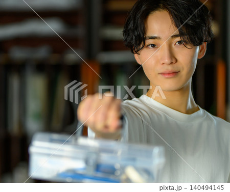 美術予備校で何かを差し出す若い男性 140494145