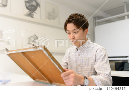 美術予備校で作品に向き合う男性 140494215
