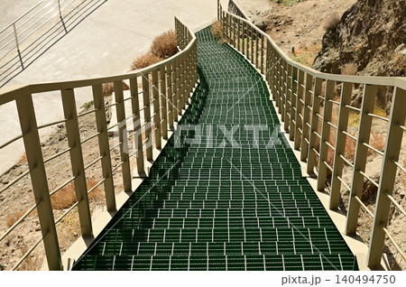 Texture or background of the green iron staircase leads to the highest viewpoint, offering a view of the ancient Banlong Street, or "Banlong Gudao," one of the most scenic routes in southern Xinjiang. Texture or background of the green iron staircase leads to the highest viewpoint, offering a view of the ancient Banlong Street, or "Banlong Gudao," one of the most scenic routes in southern Xinjiang. 140494750