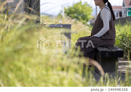 日陰のベンチで休憩している臨月の妊婦 日陰のベンチで休憩している臨月の妊婦 140496168