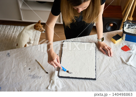 Woman making textured wall art at home 140498863