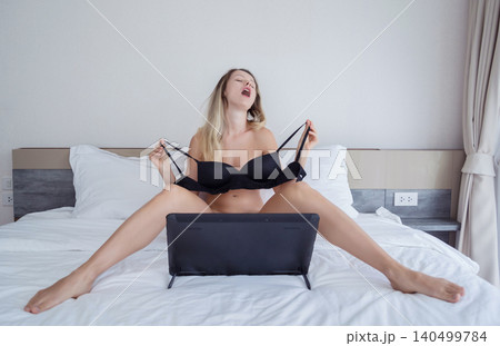 Young sexy woman posing in front of camera and working as webcam model 140499784