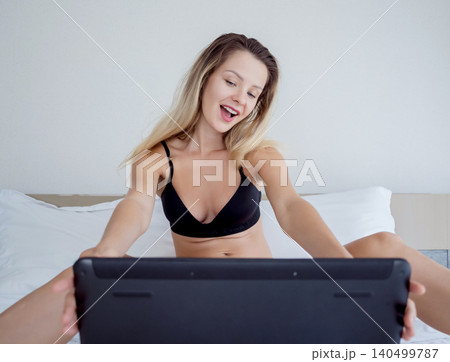 Young sexy woman posing in front of camera and working as webcam model Young sexy woman posing in front of camera and working as webcam model 140499787
