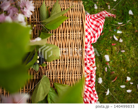 Vintage picnic basket through view of spring pink blossom tree Vintage picnic basket through view of spring pink blossom tree 140499833