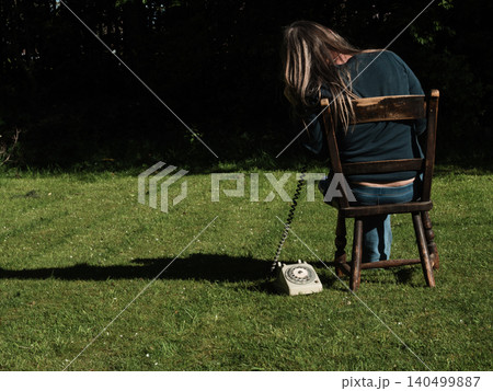Woman using vintage phone outside Woman using vintage phone outside 140499887