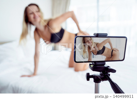 Young sexy woman posing in front of camera and working as webcam model Young sexy woman posing in front of camera and working as webcam model 140499911