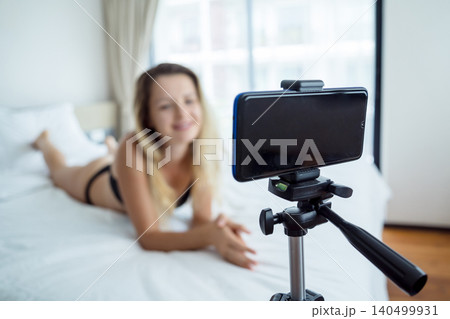 Young sexy woman posing in front of camera and working as webcam model Young sexy woman posing in front of camera and working as webcam model 140499931