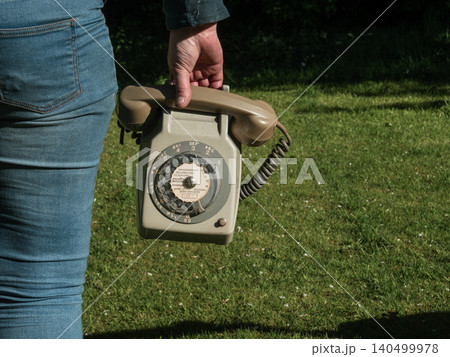 Woman holding vintage phone outside Woman holding vintage phone outside 140499978