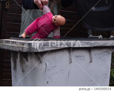 Mother putting children toy doll in the bin Mother putting children toy doll in the bin 140500014