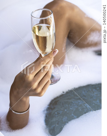 a woman drinking champagne in the jacuzzi a woman drinking champagne in the jacuzzi 140500241