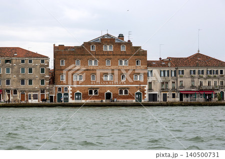 Venice, Italy - August 22, 2019 :: View of the houses and promenade of the island of Giudecca in Venice 140500731