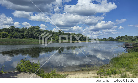 A deep river surrounded by trees and plants Thickets of reeds. Voluminous clouds A deep river surrounded by trees and plants Thickets of reeds. Voluminous clouds 140501516