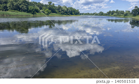 A deep river surrounded by trees and plants Thickets of reeds. Voluminous clouds A deep river surrounded by trees and plants Thickets of reeds. Voluminous clouds 140501518