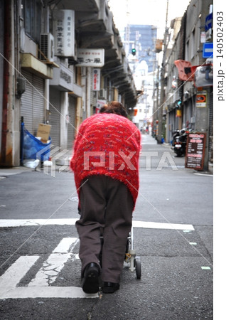 路地裏を歩く高齢女性 140502403