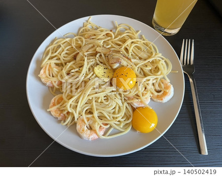 Creamy spaghetti carbonara made with rich egg yolk sauce, crispy bacon, parmesan cheese, and freshly ground black pepper for a classic, indulgent Italian pasta dish. 140502419
