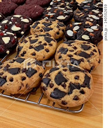 Freshly baked cookies with a golden-brown finish and chocolate chips. Perfectly crisp on the edges with a soft center, offering a delicious, comforting treat for any occasion. 140502659