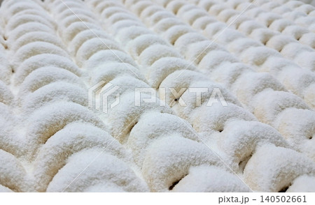 Soft and buttery putri salju cookies coated in powdered sugar, offering a melt-in-your-mouth texture with a sweet and nutty flavor. A classic Indonesian treat for special occasions. 140502661
