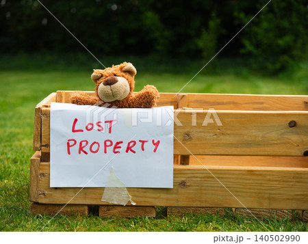 Children toy teddy bear in a wooden lost property box 140502990