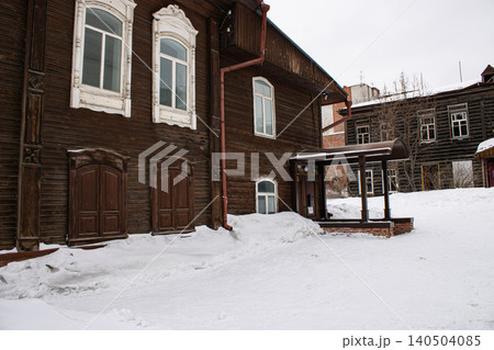 Snow-covered courtyard beside old wooden houses in winter Snow-covered courtyard beside old wooden houses in winter 140504085