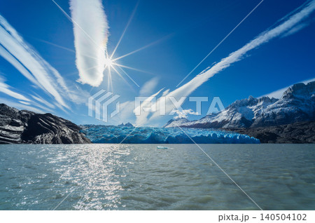 Patagonia glacier lake under blue sky and sun, dramatic mountain view Patagonia glacier lake under blue sky and sun, dramatic mountain view 140504102