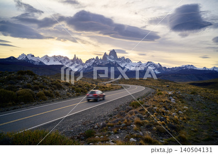 Patagonia road at sunset with mountain peak and cloudy sky 140504131