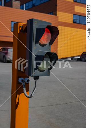 A close-up view of a traffic signal displaying a red light, emphasizing road safety and traffic management in an urban environment. A close-up view of a traffic signal displaying a red light, emphasizing road safety and traffic management in an urban environment. 140504471