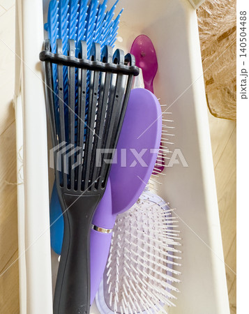A Colorful Array of Hairbrushes and Combs Organized in a Container for Personal Grooming and Hair Care Needs A Colorful Array of Hairbrushes and Combs Organized in a Container for Personal Grooming and Hair Care Needs 140504488