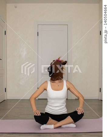 A Person Practicing Yoga at Home Wearing a Horse Mask, Combining Humor and Mindfulness in a Unique Representation of Fitness and Playfulness A Person Practicing Yoga at Home Wearing a Horse Mask, Combining Humor and Mindfulness in a Unique Representation of Fitness and Playfulness 140504664