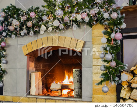 A Cozy Fireplace Surrounded by Holiday Decorations and Warm Glow of a Fire, Creating a Festive Atmosphere for Winter Celebrations 140504706